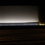 Empty movie theater with rows of seats facing a blank screen