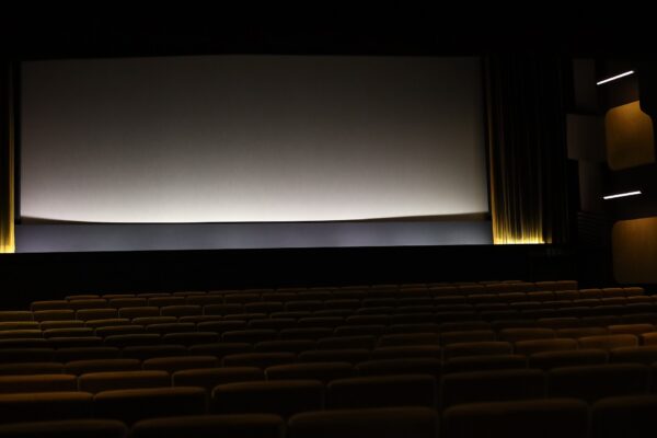 Empty movie theater with rows of seats facing a blank screen