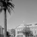Black-and-white photo of the copper-domed Arizona State Capitol with palm trees