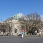 Exterior of the Grand Palais in Paris with its glass roof, columns and bronze sculpture