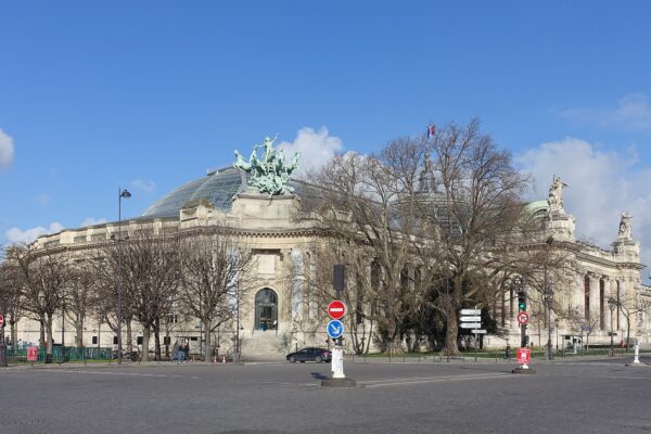Exterior of the Grand Palais in Paris with its glass roof, columns and bronze sculpture