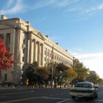 Exterior of the U.S. Department of Justice building along a tree-lined street