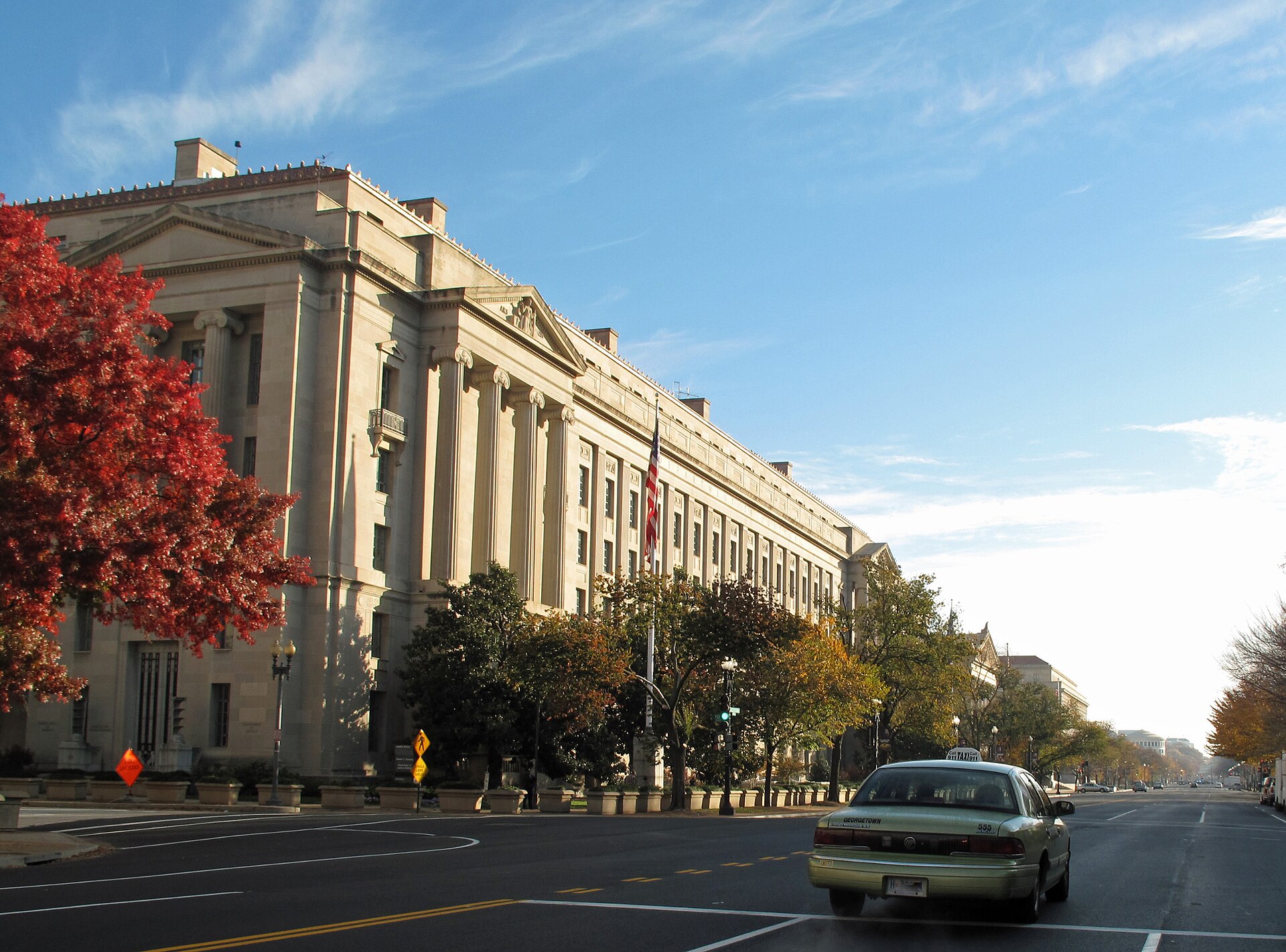 Exterior of the U.S. Department of Justice building along a tree-lined street