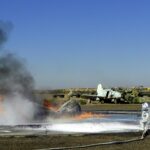 Marine firefighters spraying foam on a burning training aircraft mockup at MCAS Yuma