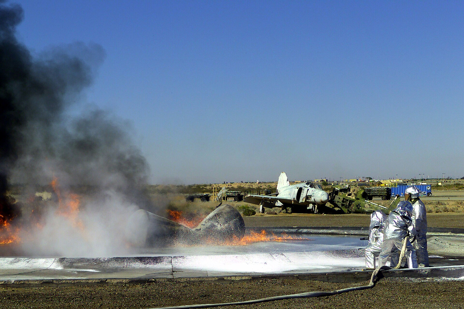 Marine firefighters spraying foam on a burning training aircraft mockup at MCAS Yuma