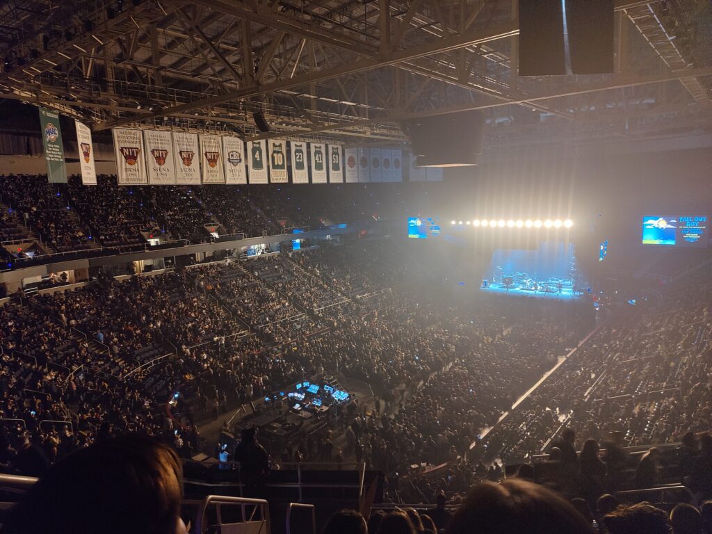 Jimmy Eat World performing on a lit stage in a packed arena