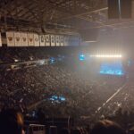 Jimmy Eat World performing on a lit stage in a packed arena