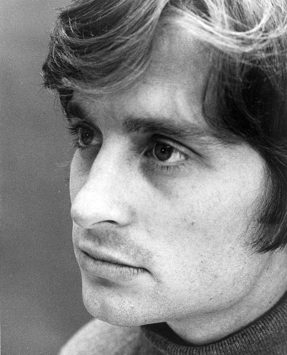 Black-and-white portrait of a young Michael Douglas with tousled hair, 1969