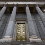 Neoclassical facade of Spain's Congress of Deputies building in Madrid with lion statues