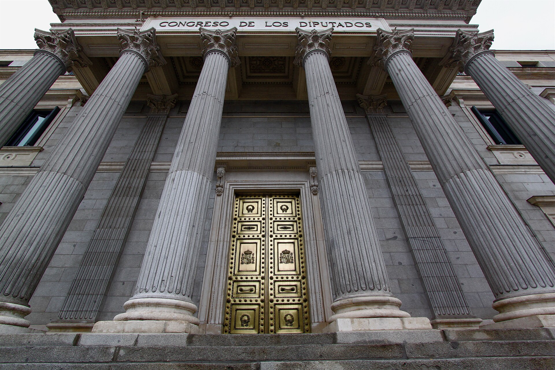 Neoclassical facade of Spain's Congress of Deputies building in Madrid with lion statues