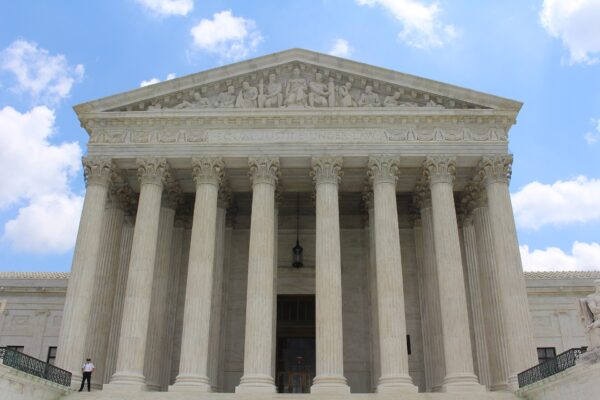 White marble columns and facade of the U.S. Supreme Court building under a blue sky