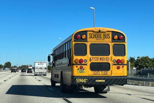 Rear view of a yellow school bus driving on a Florida highway